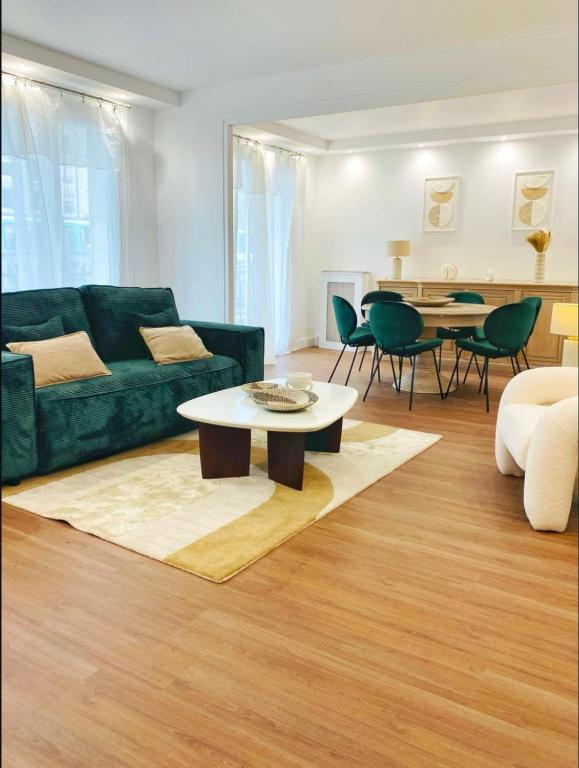 un salon avec un canapé vert et une table dans l'établissement Gare du Nord - Large renovated apartment, à Paris