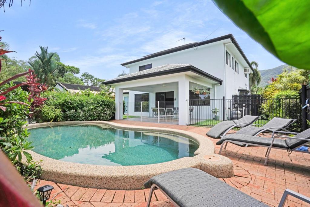 a swimming pool in front of a house at Palm Cove House in Trivia in Palm Cove