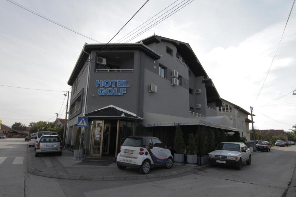 un edificio de hotel con coches estacionados frente a él en Hotel Golf, en Kruševac