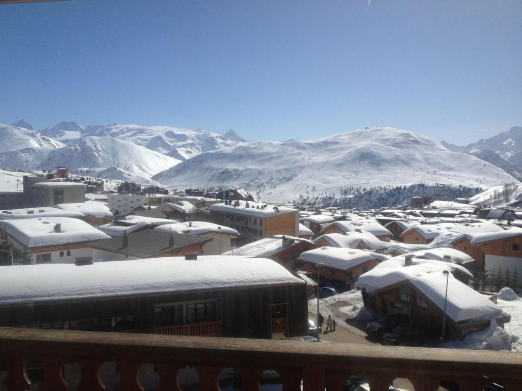 une ville couverte de neige avec des montagnes en arrière-plan dans l'établissement Fantastic appart ski aux pieds, à L'Alpe-d'Huez