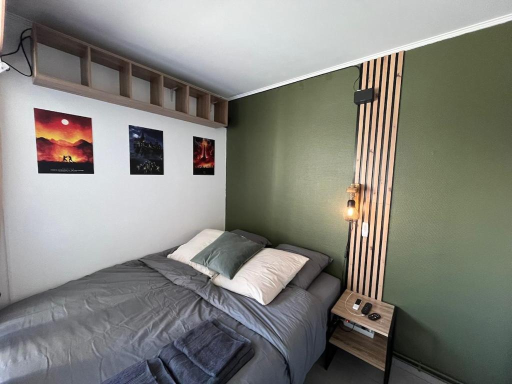 - une chambre avec un lit dans un mur vert dans l'établissement Pop corn Palace, à Annemasse