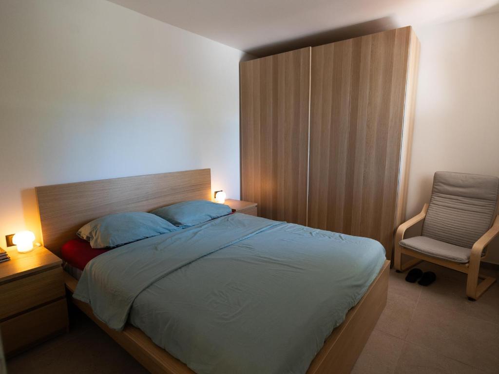 Un dormitorio con una cama con almohadas azules y una silla en Villa Mrvica - Bilo, Primosten, en Otok Trara