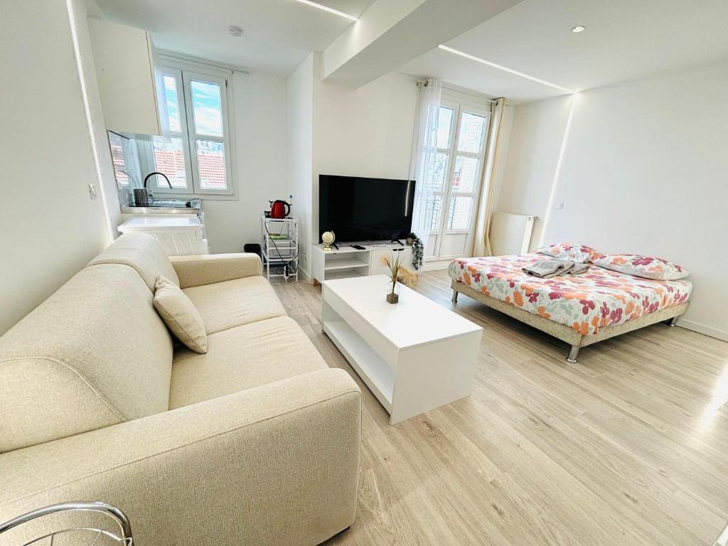 un salon avec un canapé et un lit dans l'établissement République rue des bluets Paris, à Paris