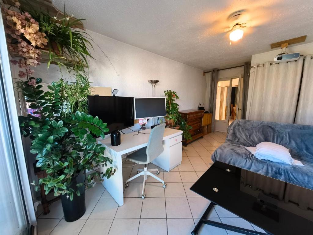 Cette chambre comprend un bureau avec un ordinateur et un canapé. dans l'établissement Apartment - nice view and quiet, à Montpellier
