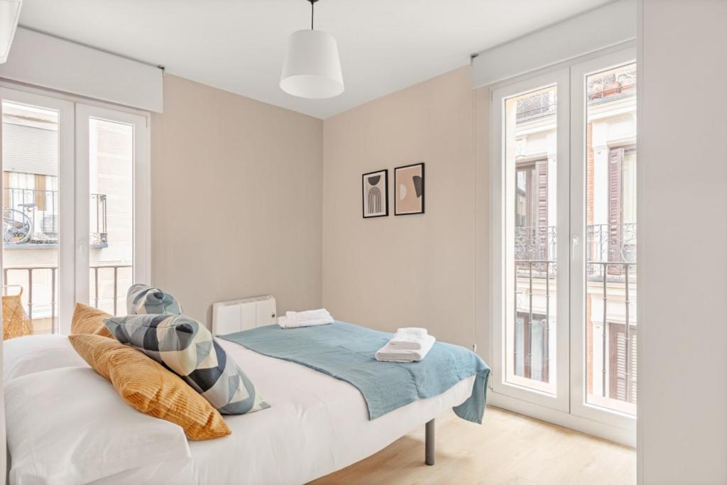 biała sypialnia z łóżkiem i 2 oknami w obiekcie 2 bedrooms 1 bathroom furnished - Las Letras - Bright - MintyStay w Madrycie