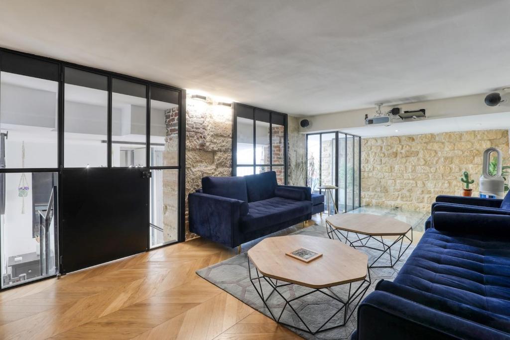 un salon avec un canapé bleu et une table dans l'établissement Beautiful loft 130m2 Louvre Palais Royal - II, à Paris