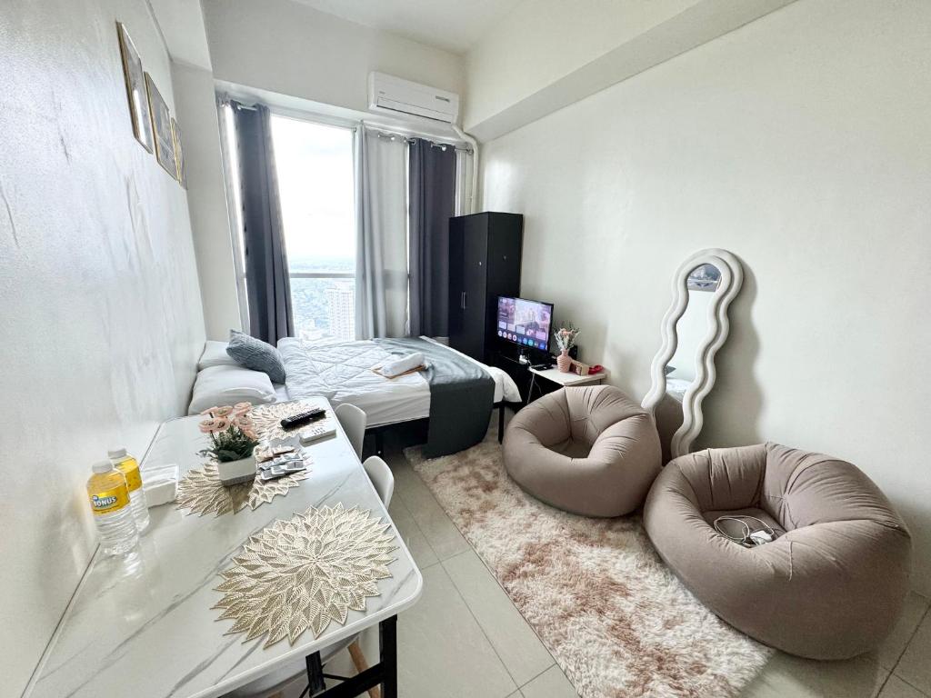 a living room with two chairs and a table at The Wild Roces Makati, The Beacon Residences in Manila