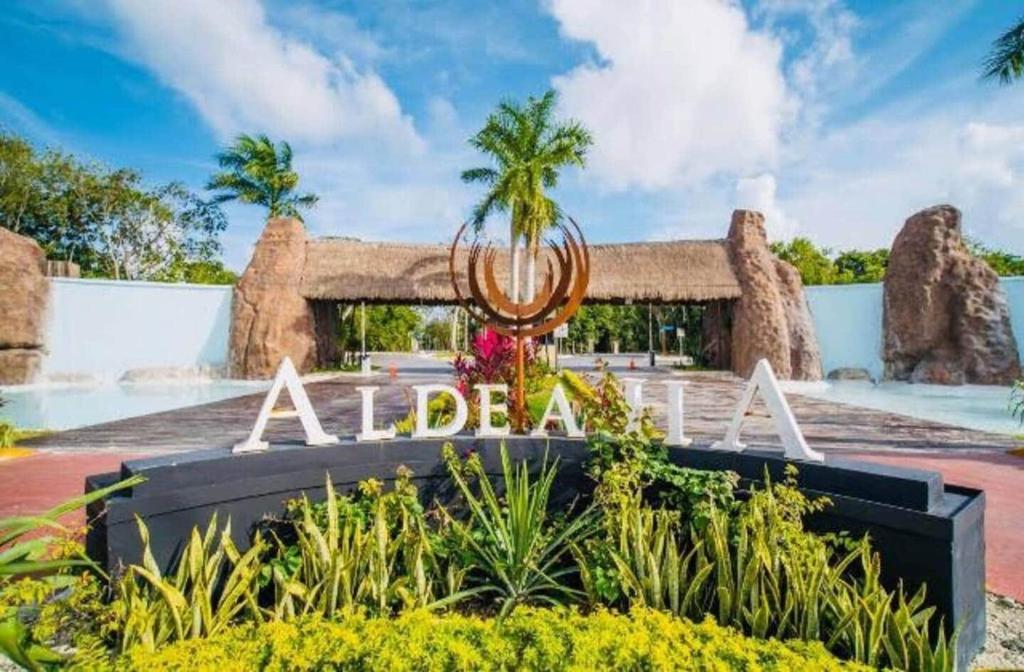 a sign in front of a resort with a fountain at Casa Luz in Puerto Morelos