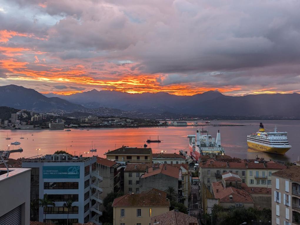 un bateau de croisière est amarré dans un port au coucher du soleil dans l'établissement Centre ville avec vue magnifique sur le golfe d'Ajaccio; parking privé., à Ajaccio