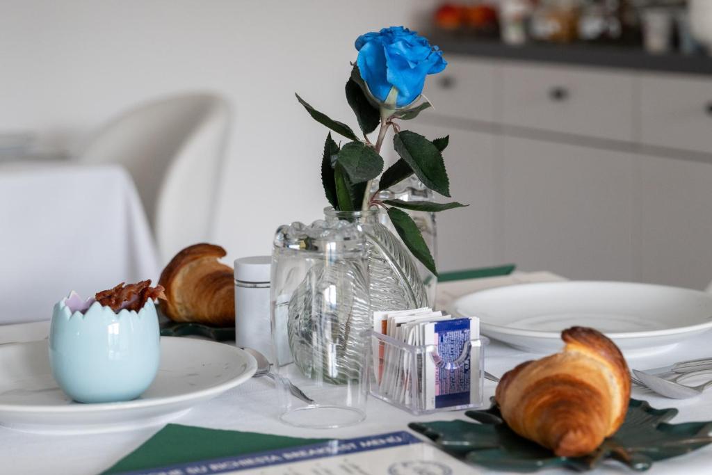 a blue rose in a glass vase on a table at B&B I LAKE IT BELLAGIO in Bellagio
