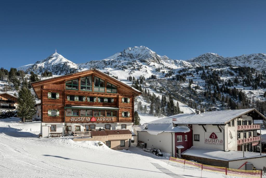 budynek w śniegu z górami w tle w obiekcie AUSTRIA APPART - natural Lifestyle Appartements auf der Piste w mieście Obertauern