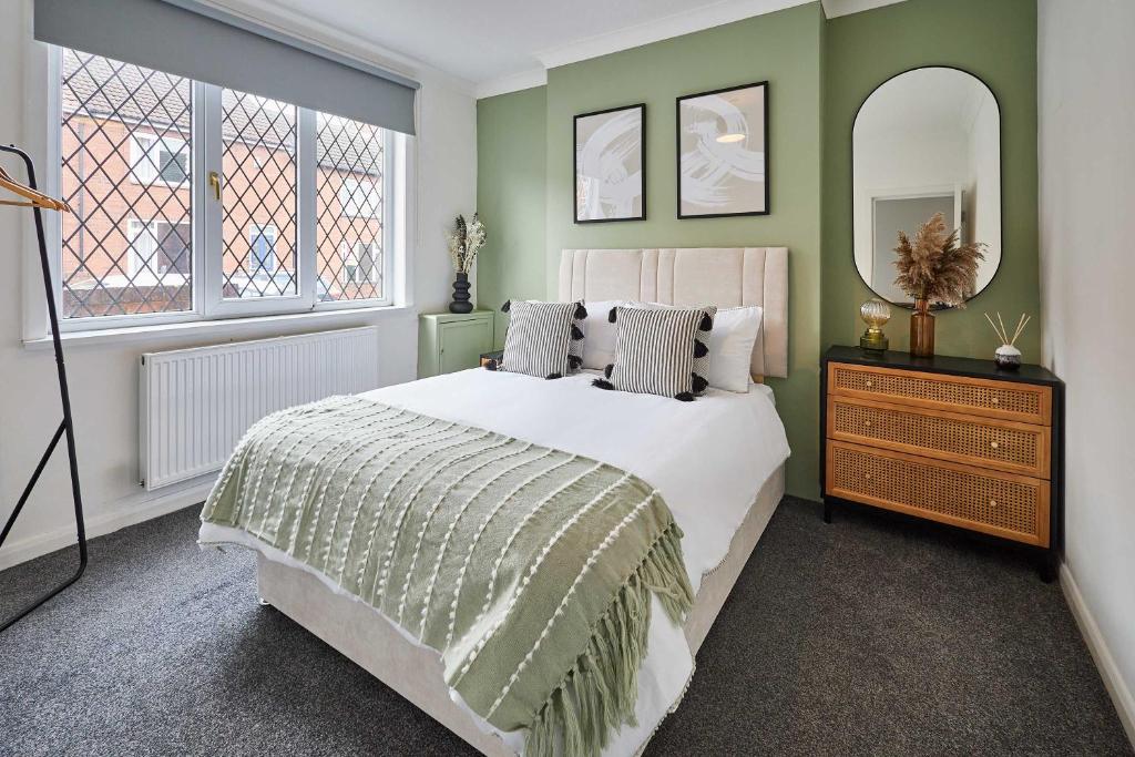 a bedroom with a bed and a dresser and two windows at Host & Stay - Joffre Avenue in Castleford