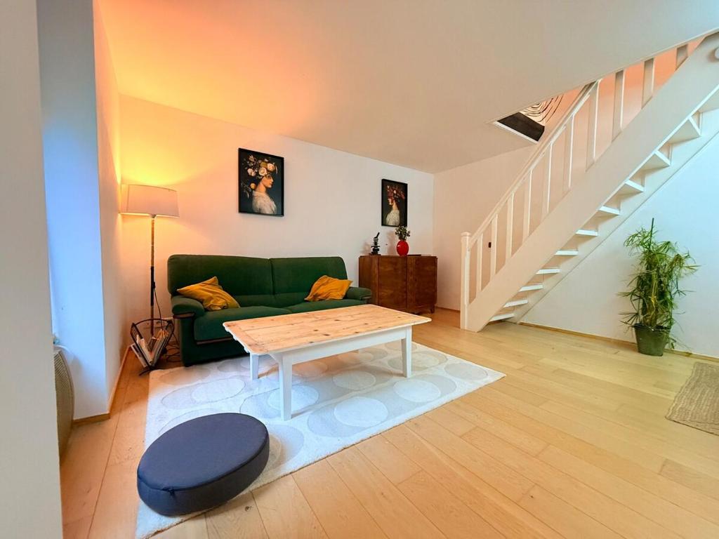 a living room with a green couch and a table at Apartment 6 prsn avec Terrasse Proche Centre-ville in Besançon