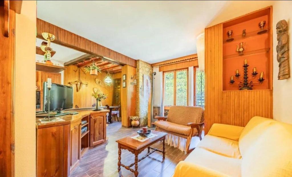 un soggiorno con un divano e una TV di La casa di Sara a Limone Piemonte