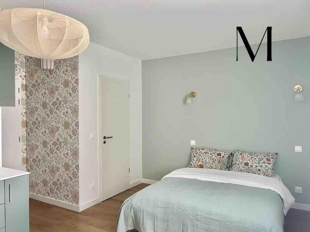 ein Schlafzimmer mit einem Bett in einem weißen Raum in der Unterkunft M033 superbe studio centre ville in Annemasse