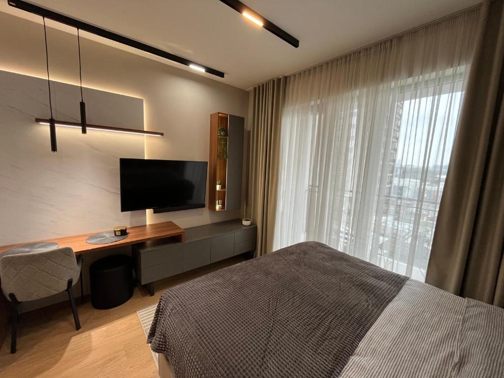 a bedroom with a bed and a desk with a television at Belgrade Waterfront River View Apartments in Belgrade