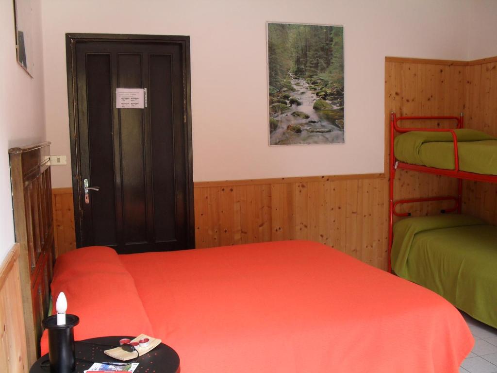 a bedroom with two beds and a door to a room at La Miando Rooms in Salza di Pinerolo