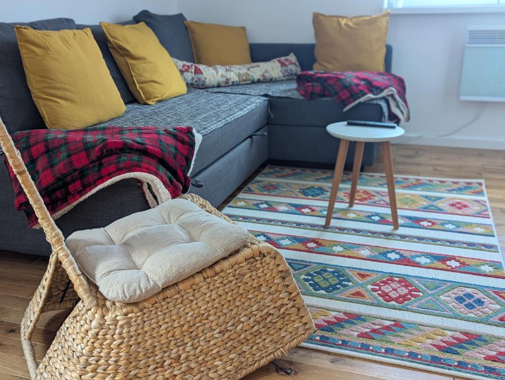 a wicker chair in a living room with a couch at Kopaonička priča in Kopaonik
