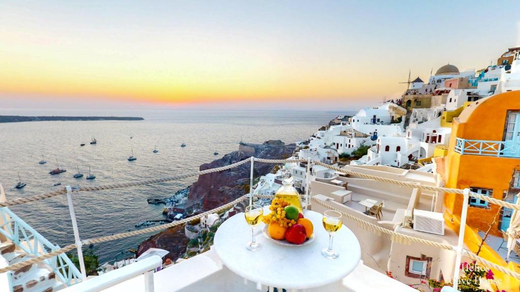 a table with fruit and wine glasses on a cruise ship at Santorini Paradise Cave Houses in Oia