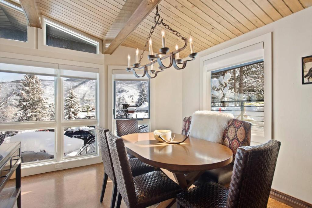 a dining room with a table and chairs and windows at Shadow Mountain 04 in Aspen