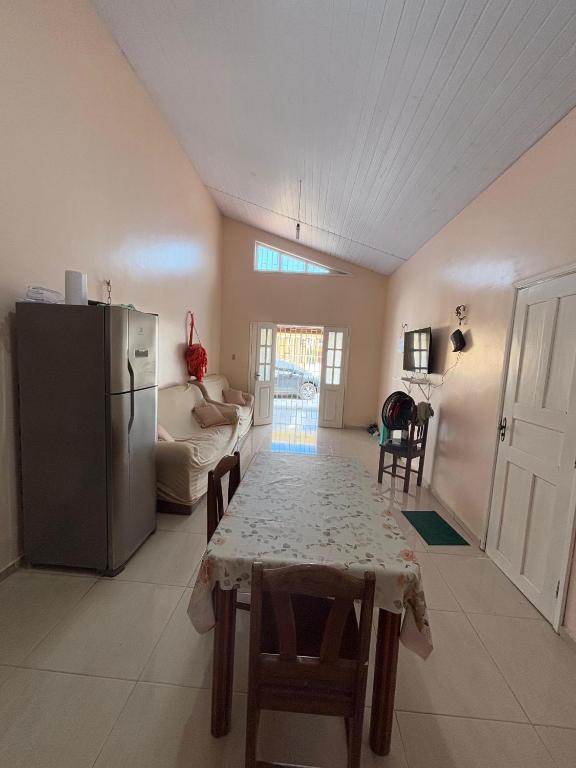 a living room with a table and a refrigerator at Salinas Atalaia in Salinópolis