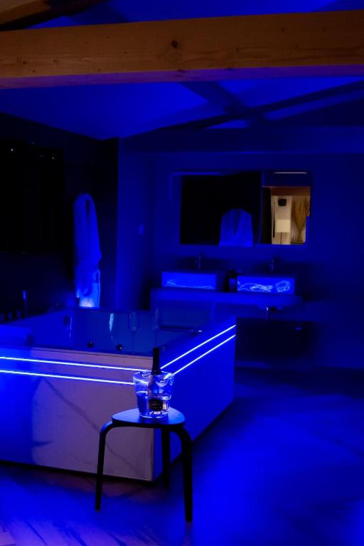 a dark room with a table and blue lights at L Atelier by VIP in Saint Die