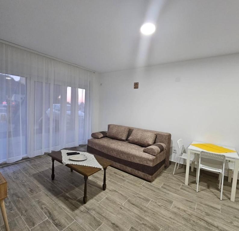 een woonkamer met een bank en een tafel bij Apartman Gong in Divčibare