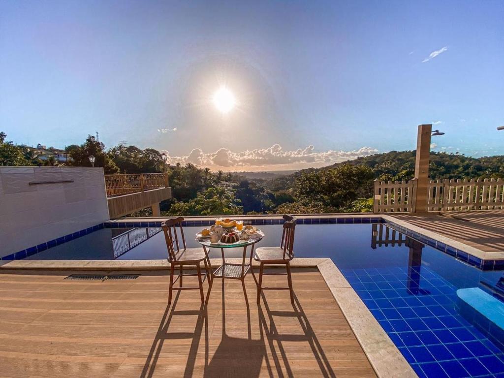 a patio with a table and chairs on a swimming pool at Recanto sol nascente in Rio Formoso