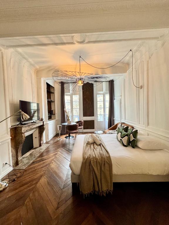 une chambre avec un grand lit et un salon dans l'établissement Les lices, centre ville de Rennes, à Rennes