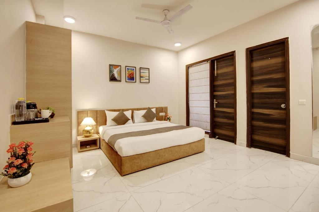 a bedroom with a king sized bed and wooden doors at Limewood Stay - Corporate Huda City Centre in Gurgaon