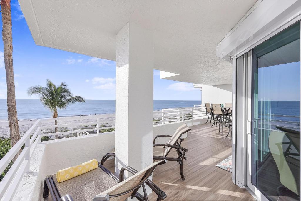 a balcony with chairs and a view of the ocean at Somerset three-bedroom end unit beachfront condo in Marco Island