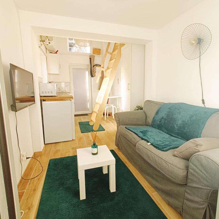 un salon avec un canapé et une table dans l'établissement Nest- Tiny house avec Jardin, proche gare, Luxembourg-Metz, à Uckange