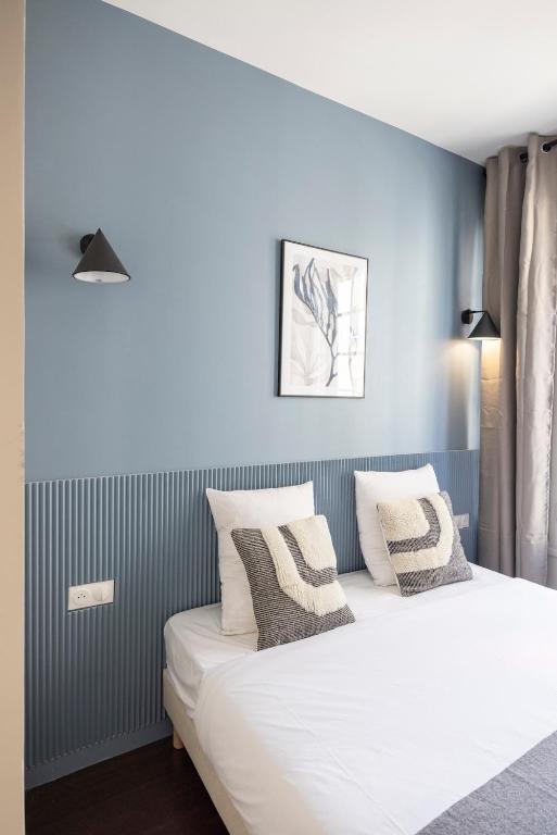 une chambre avec un grand lit blanc avec des murs bleus dans l'établissement Serenity spot 5 minutes away from Paris-II, à Le Pré-Saint-Gervais