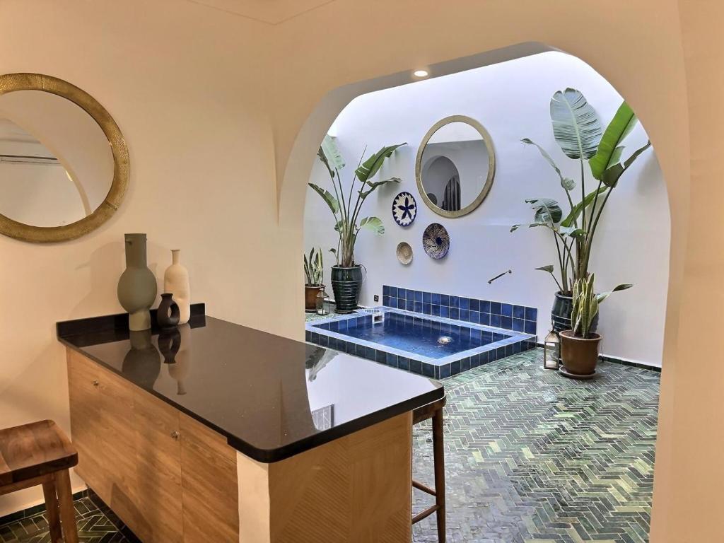a bathroom with a tub in a room with plants at Riad entièrement privatisé 5 suites riad avec bassin pres de la célèbre place Jemaa El Fna le petit déjeuner et le ménage quotidien compris in Marrakech