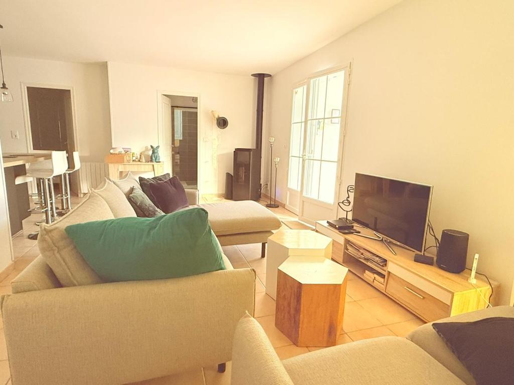 a living room with two couches and a flat screen tv at Maison de Charme 3 étoiles à 300m de la plage in Saint-Pierre-dʼOléron
