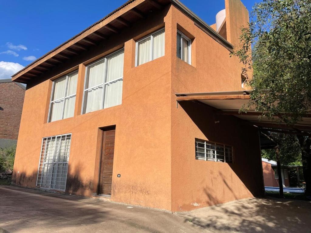 ein großes Backsteingebäude mit einer Tür an der Seite in der Unterkunft Casa con pileta - Rio Ceballos - a 5 min del centro - Hermosa vista a las sierras in Río Ceballos