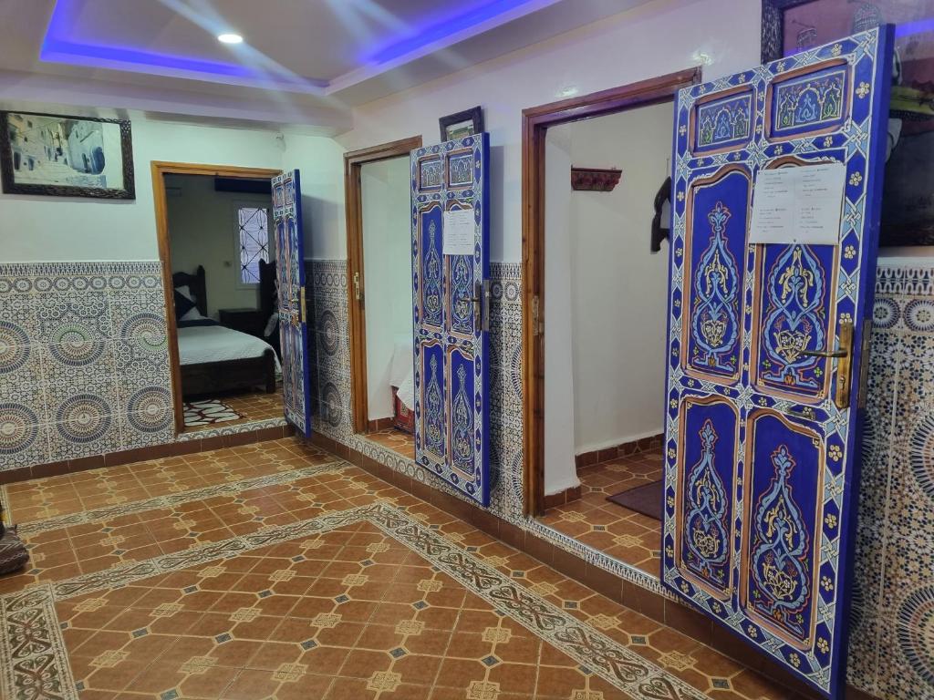 シェフシャウエンにあるHotel Al kassabaの青と白のドアと鏡が備わるお部屋
