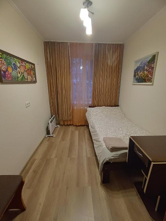 a bedroom with a bed and a desk and a window at Cozy rooms near beautiful Park 1st Floor in Chişinău