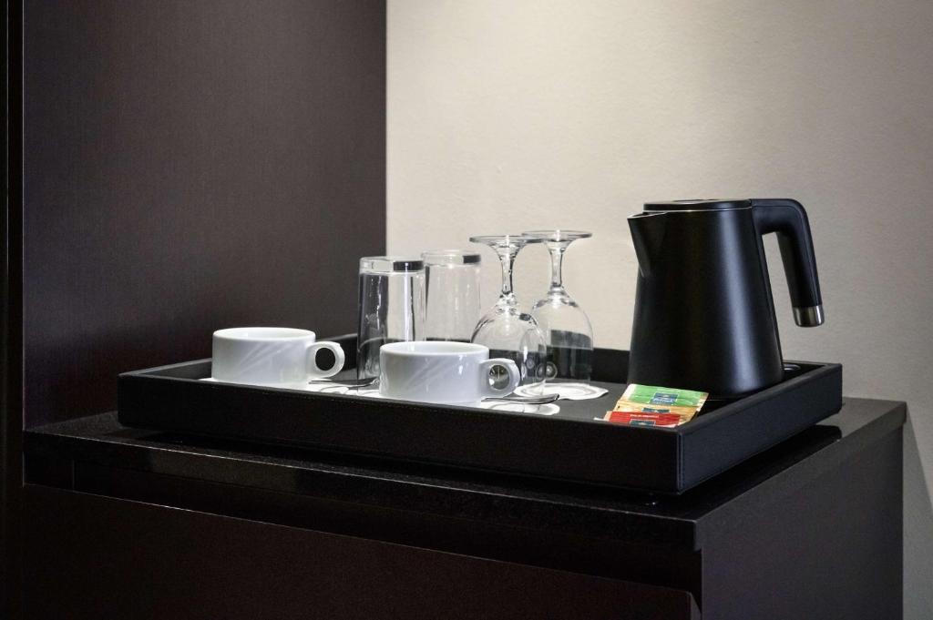 a black tray with cups and coffee makers on a table at Svelte Delhi, a member of Radisson Individuals in New Delhi