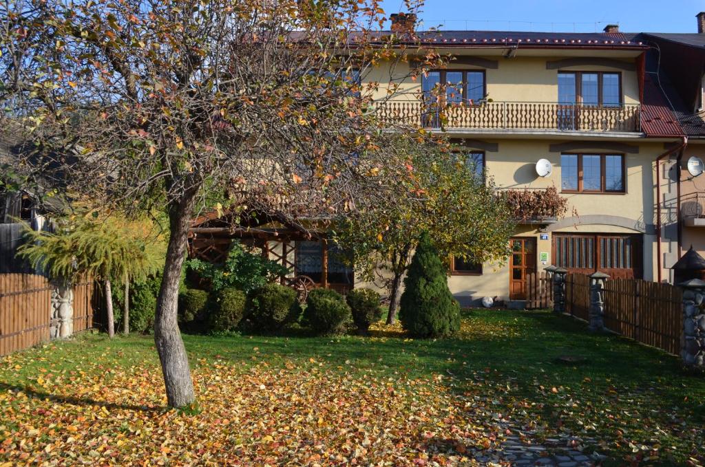 a house with a tree in the yard at Agroturystyka Chmiel in Sromowce Wyżne