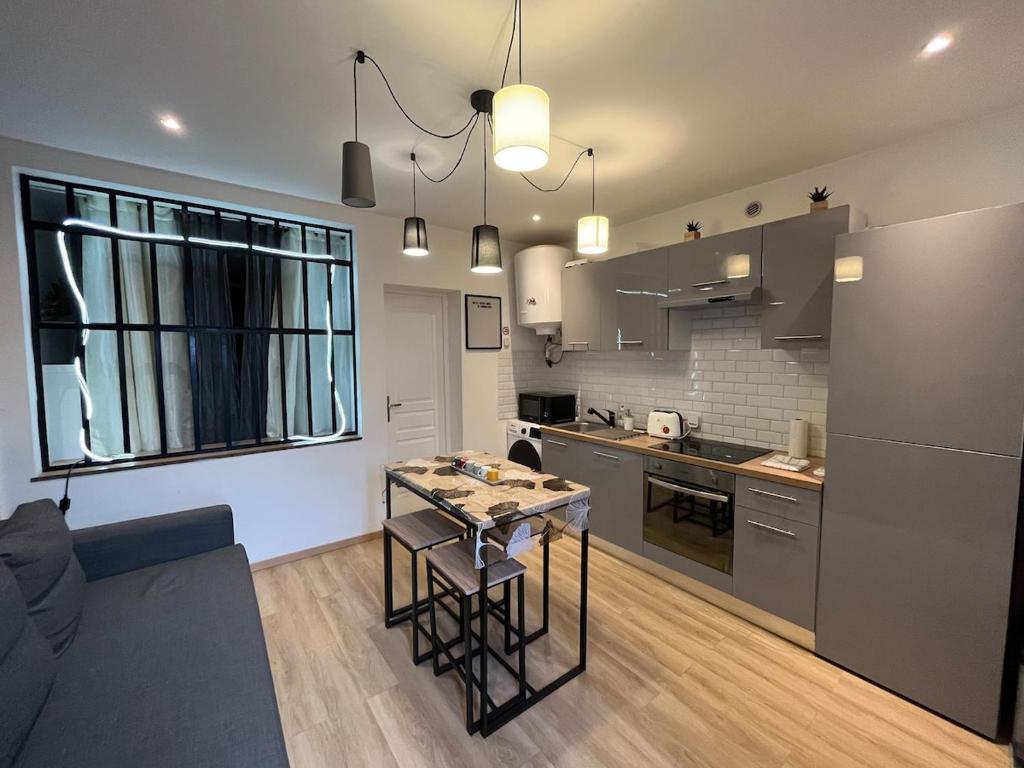 une cuisine et un salon avec une table dans une pièce dans l'établissement T2 Modern and Cosy in St Étienne, à Saint-Étienne
