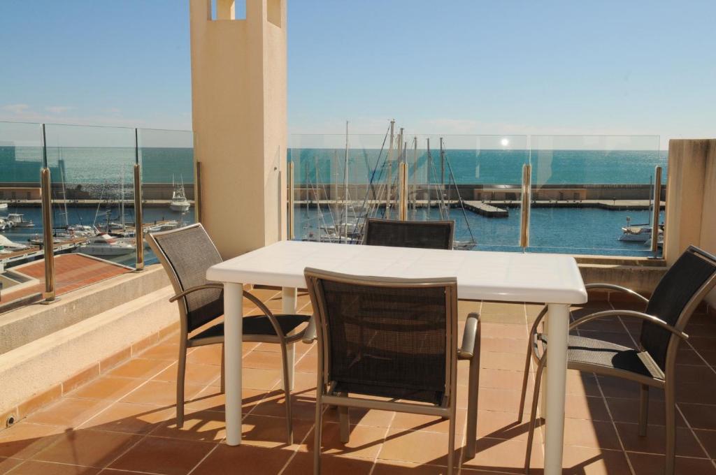 a table and chairs on a balcony with a view of a harbor at Residencial Marina de Port in L'Ametlla de Mar