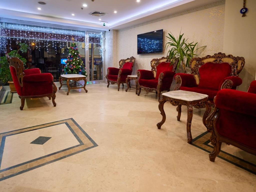 a waiting room with red chairs and a christmas tree at Istanbul Newcity Hotel in Istanbul