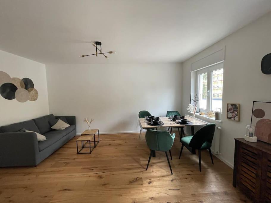 a living room with a table and a couch at Schöne 2 Zimmer Wohnung Kingsize-Bett in Augsburg