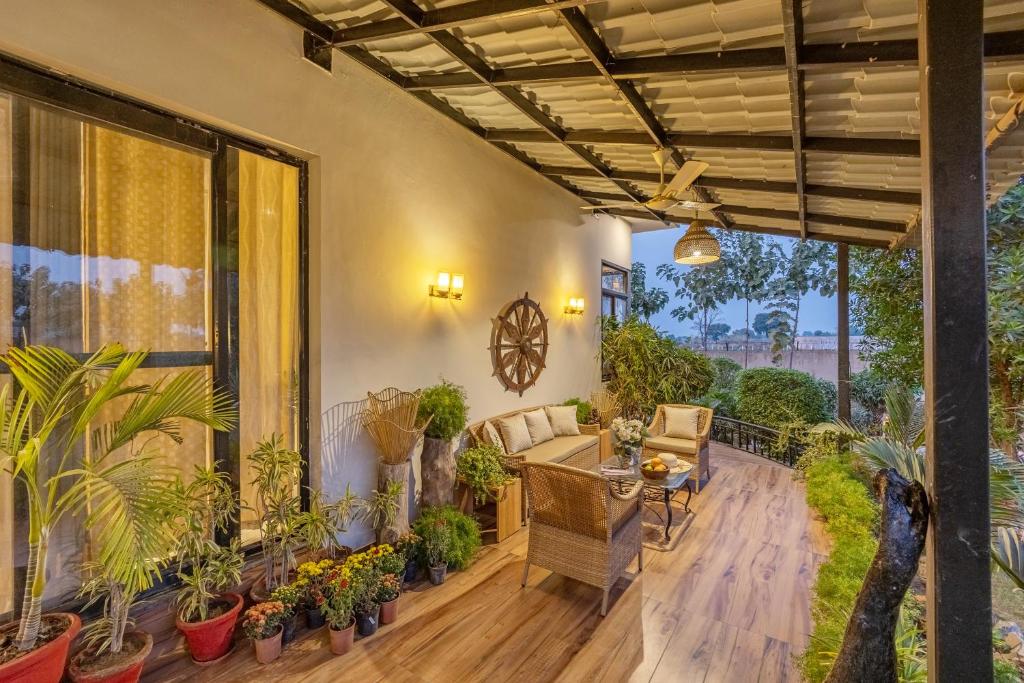 a patio with a table and chairs and plants at Alaya Stays Dacha 3 BHK Villa with Jacuzzi & Outdoor Bar in Palwal