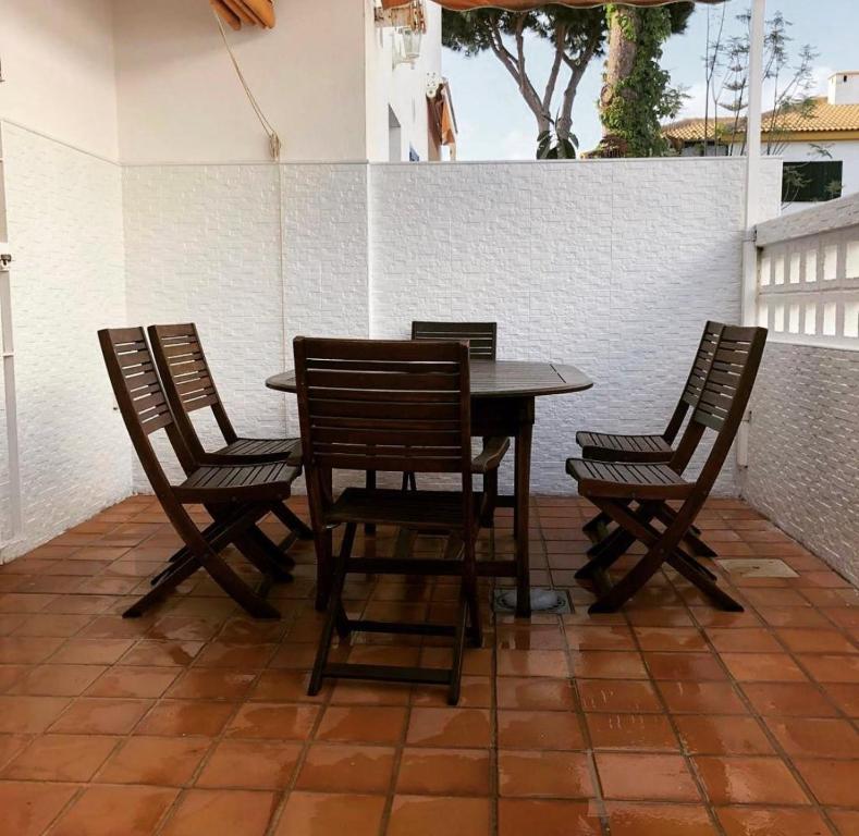 a wooden table and four chairs on a patio at casa en Islantilla in Isla Cristina
