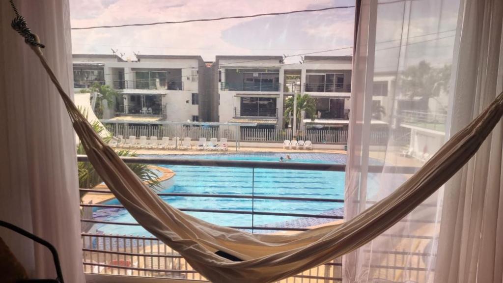 een hangmat voor een raam met uitzicht op een zwembad bij Apartasol Familiar 2 in Santa Fe de Antioquia