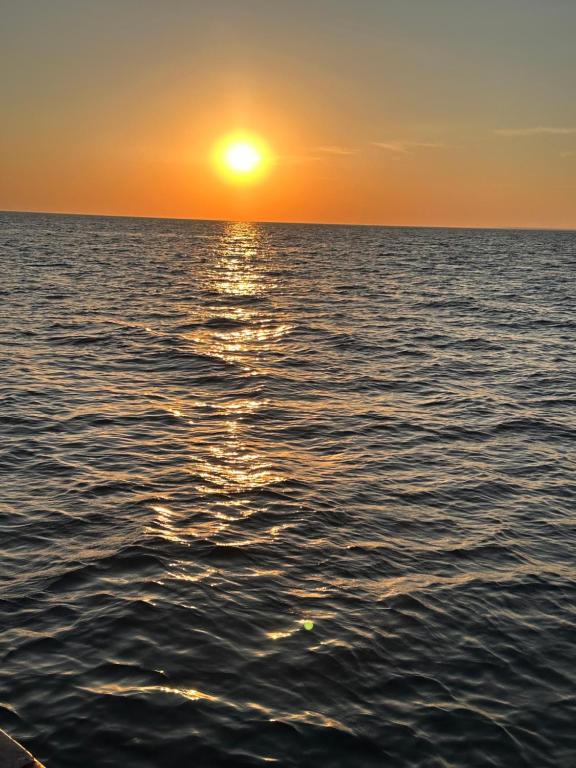 ein Bild eines Sonnenuntergangs über dem Meer in der Unterkunft Casa aconchegante em Indaiá Bertioga Pertinho do mar in Bertioga