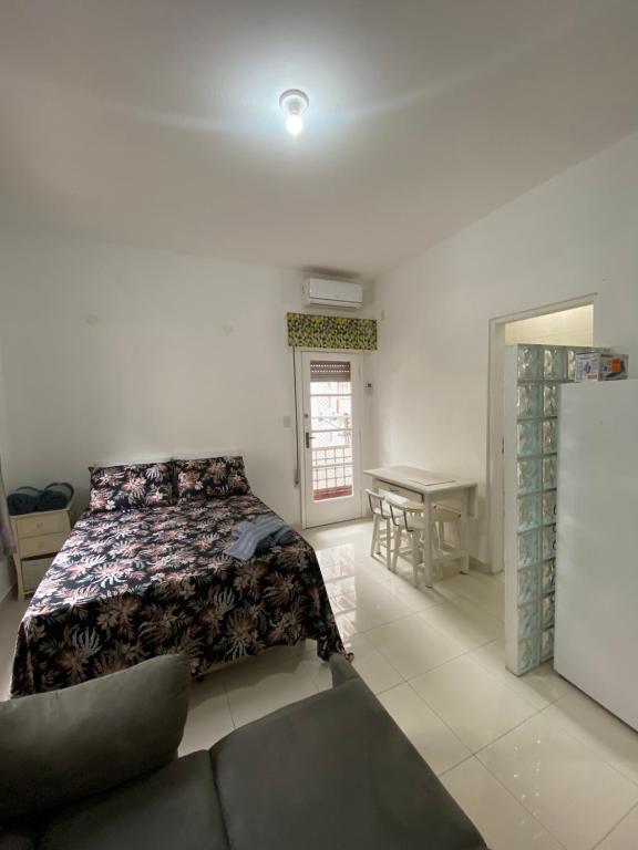 une chambre avec un lit, un canapé et une table dans l'établissement Apto Santos Gonzaga 45 mtrs Praia, à Santos