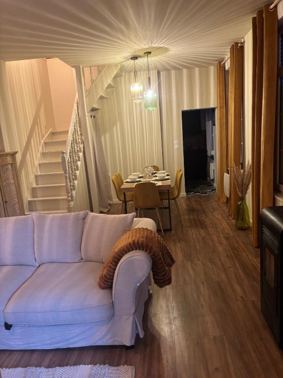a living room with a white couch and a table at Appartement des Capucins in Cambrai